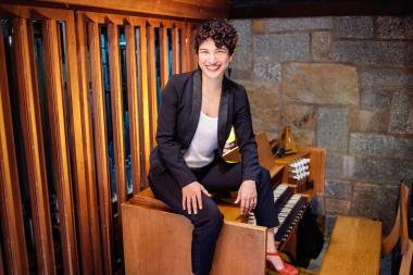 Organist Joy-Leilani Garbutt seated on a pipe organ