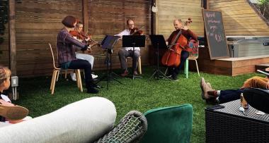 Musicians playing in a backyard on green grass