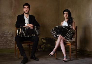 Man and woman seated holding bandoneones